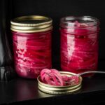 oignon rouge mariné dans deux pots de conserve
