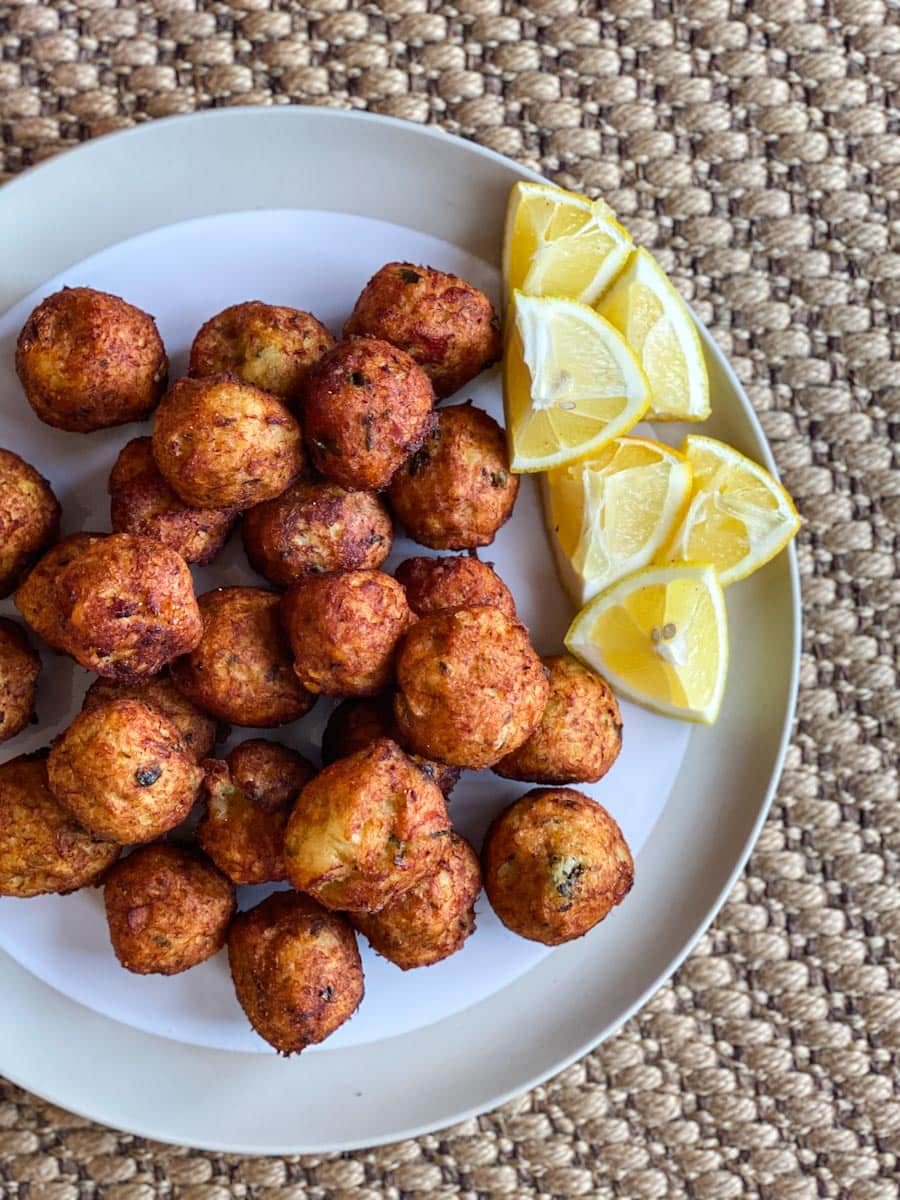 accras de morue dans une assiette avec quartiers de citron