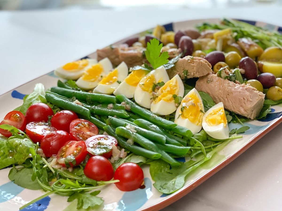 grande salade niçoise maison dans une grande assiette de service ovale