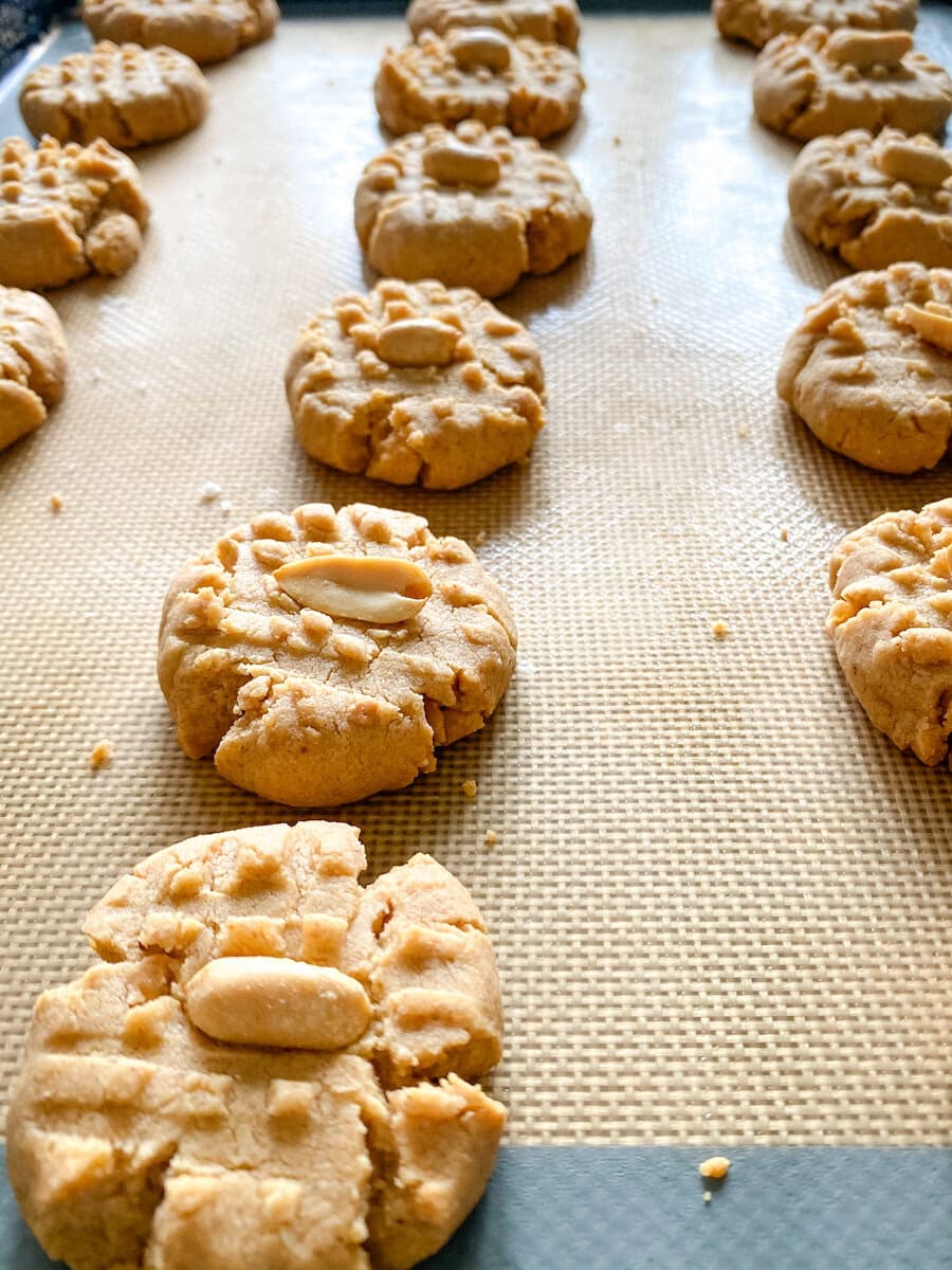 des biscuits au beurre d'arachide avec arachide sur le dessus sur une plaque et silpat