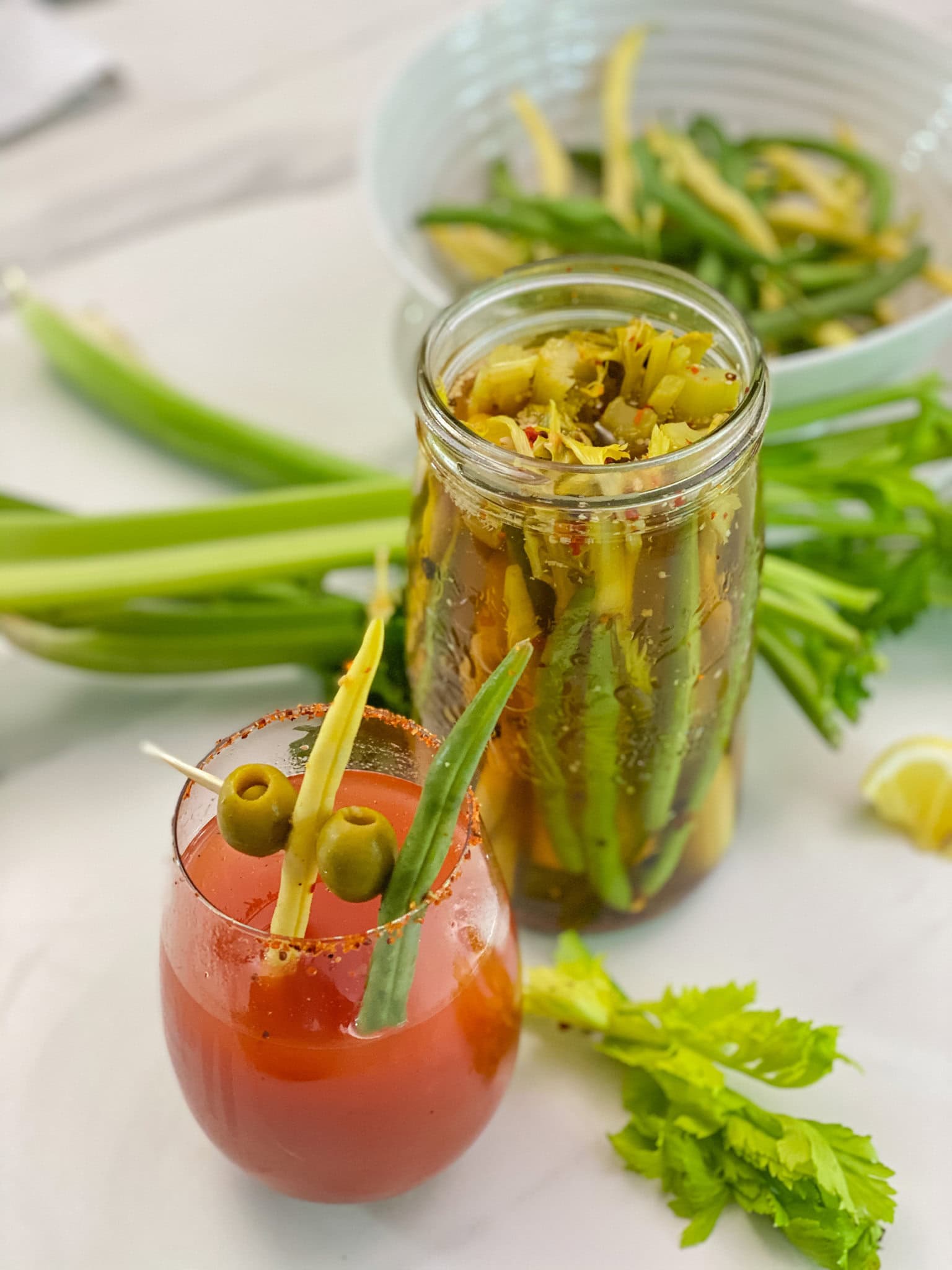 céleri et haricots marinés avec cocktail bloody ceasar en avant plan