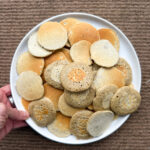 main tenant une assiette de blinis dorés