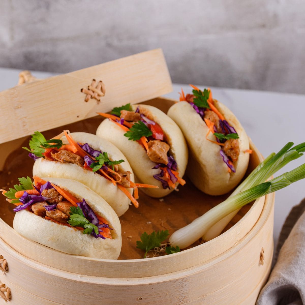 pains bao tout garnis dans un panier en bambou