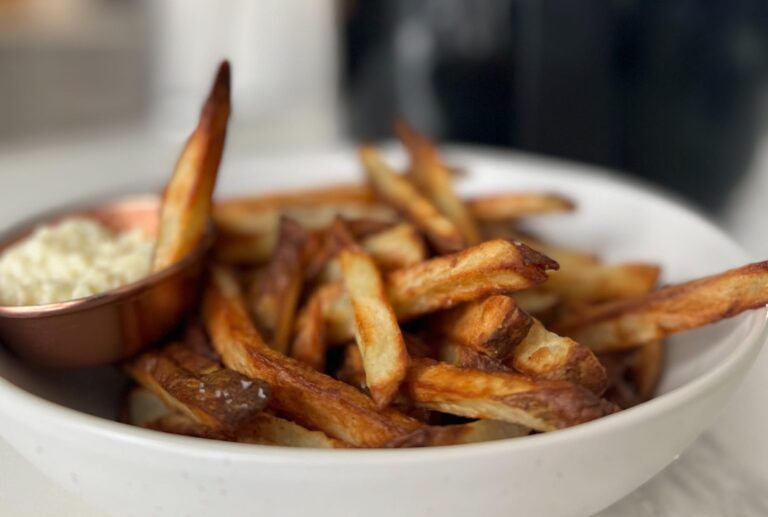 frites croustillantes dans un bol devant un air fryer