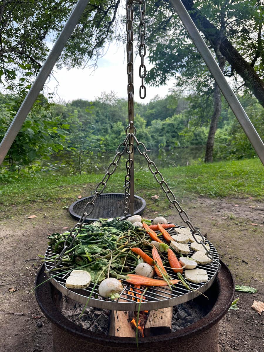 petromax trepied de cuisson sur grille avec légumes sur le feu