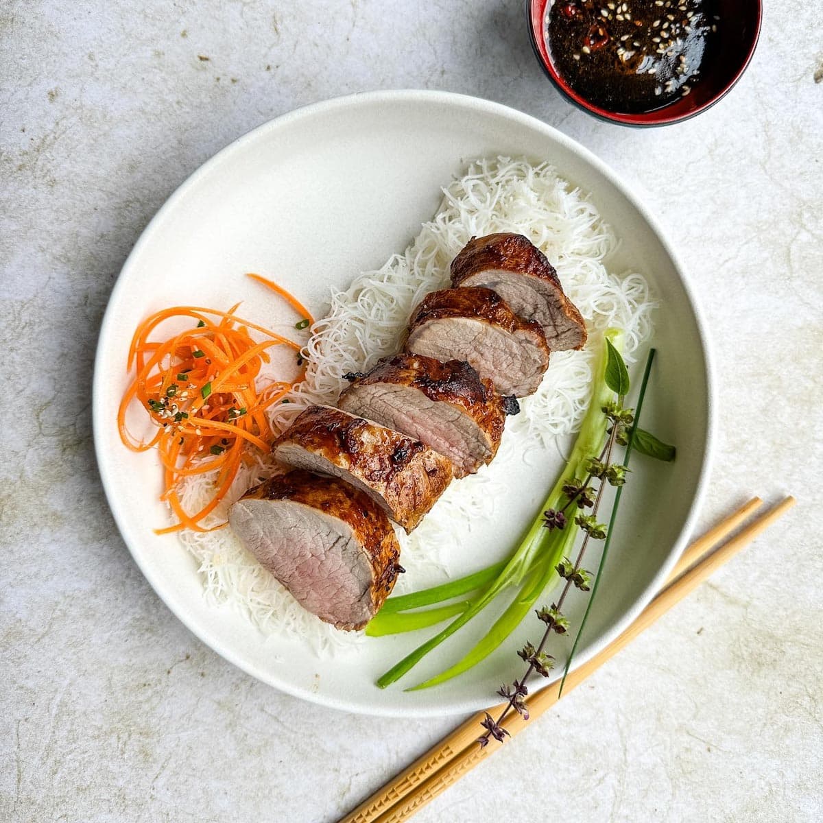 filet de porc teriyaki cuit au air fryer dans assiette avec carotte, riz et oignon vert.