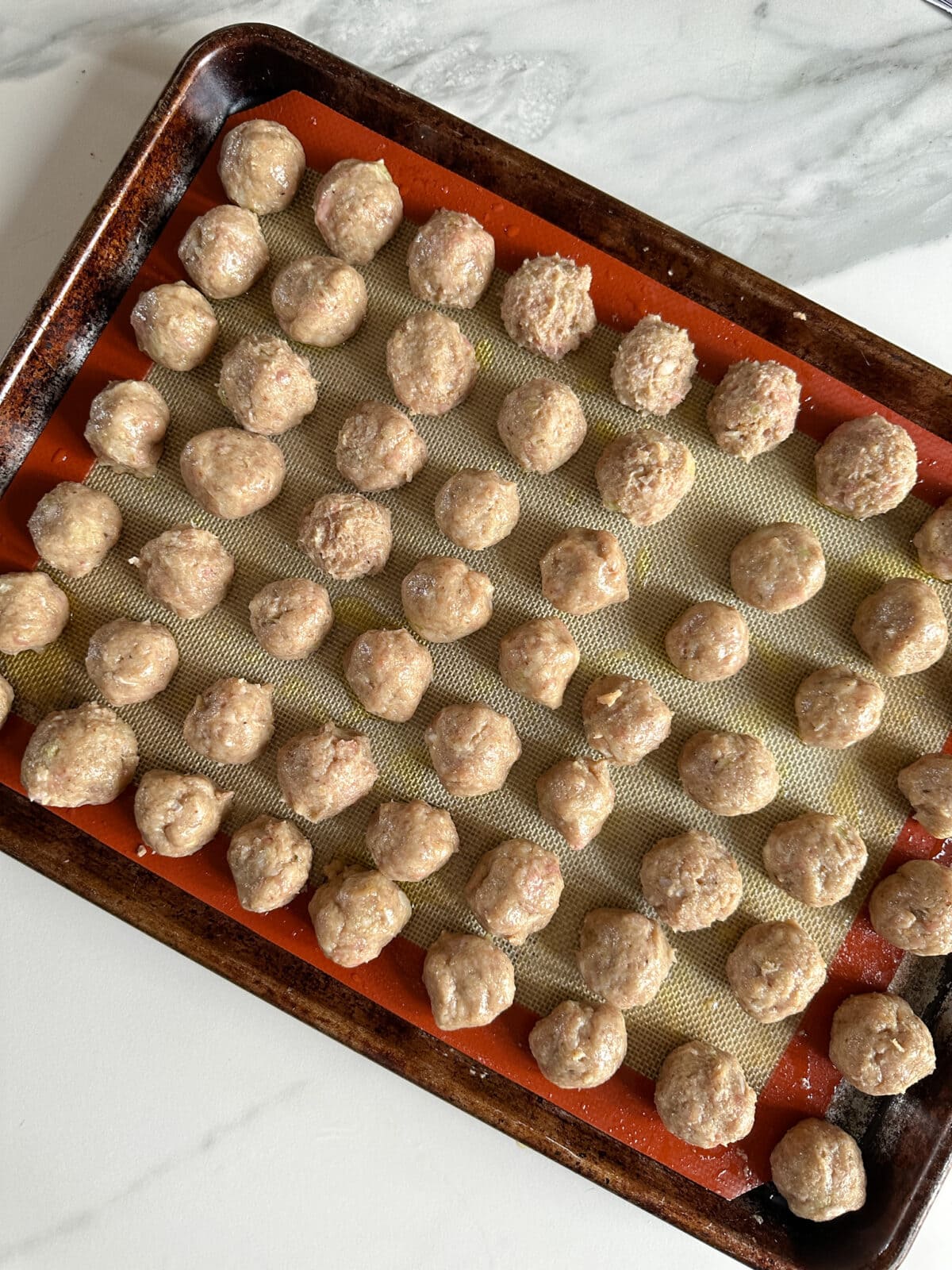 petites boulettes de poulet haché sur une plaque 