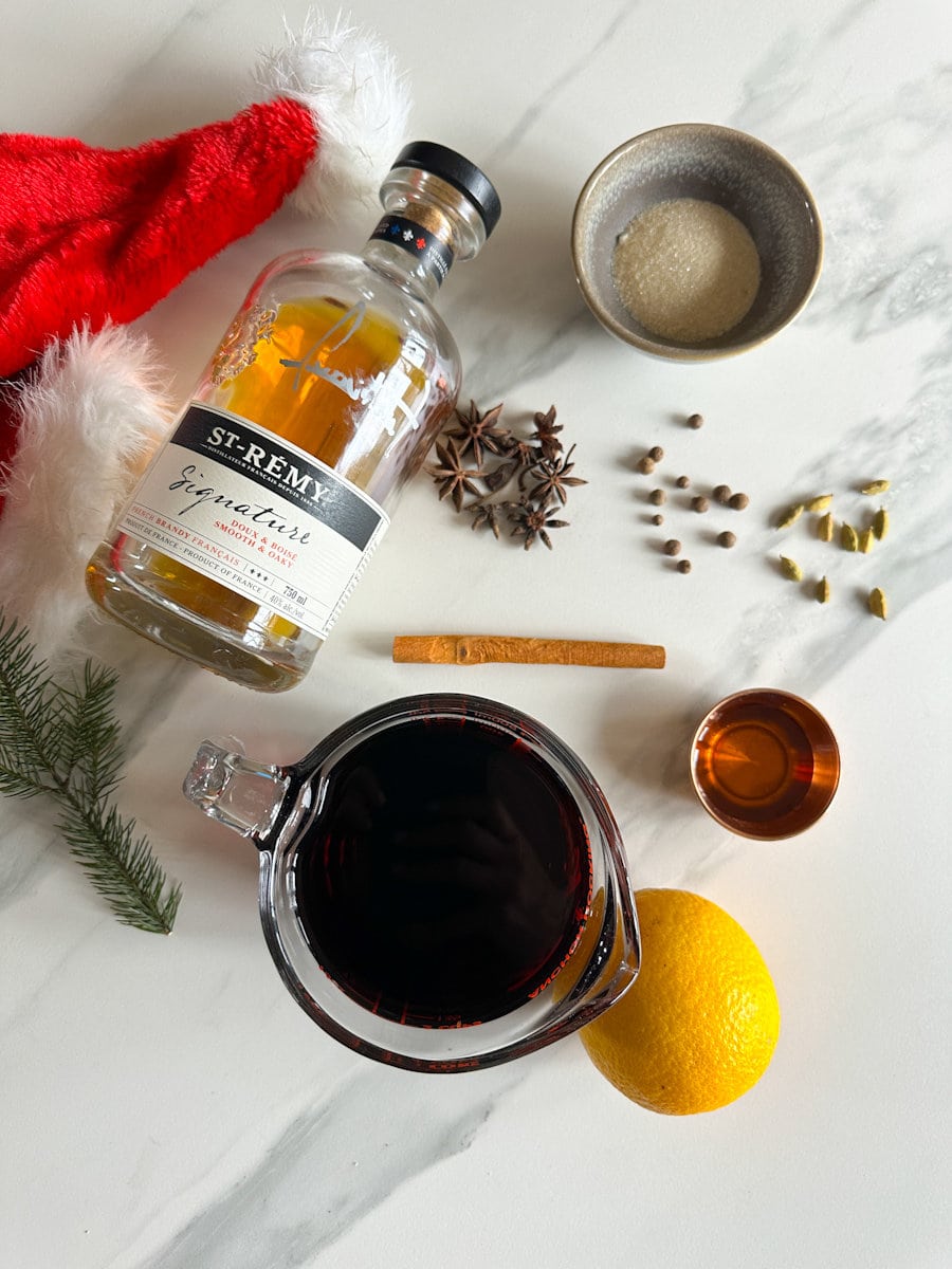 ingrédients vin chaud aux épices: cannelle, sucre, citron, vin rouge, brandy, muscade, piment de la Jamaique, poivre, cannelle
