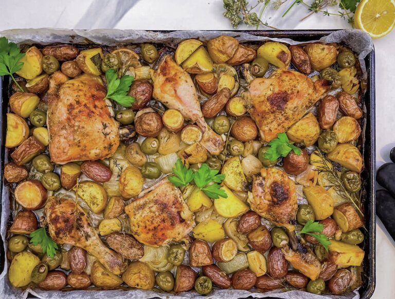 poulet au four à la grecque sur une plaque avec pommes de terre, citron, olives, herbes et citron