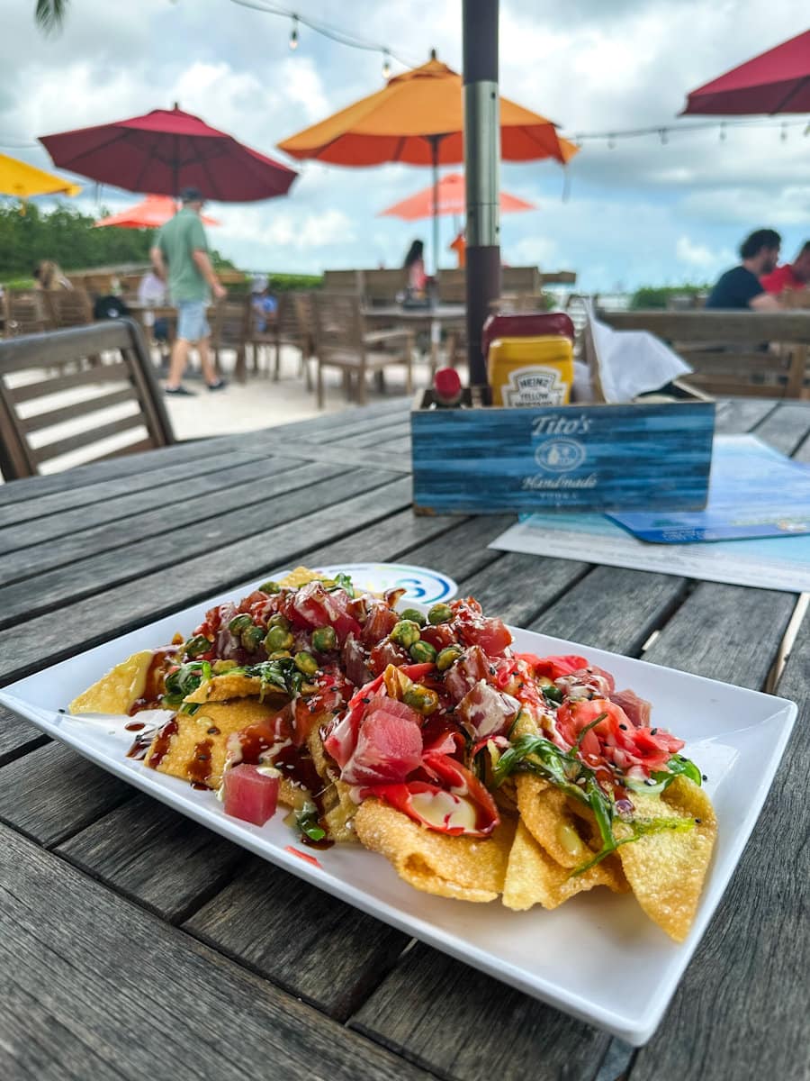 poke nachos sur une table en bois sous un parasol