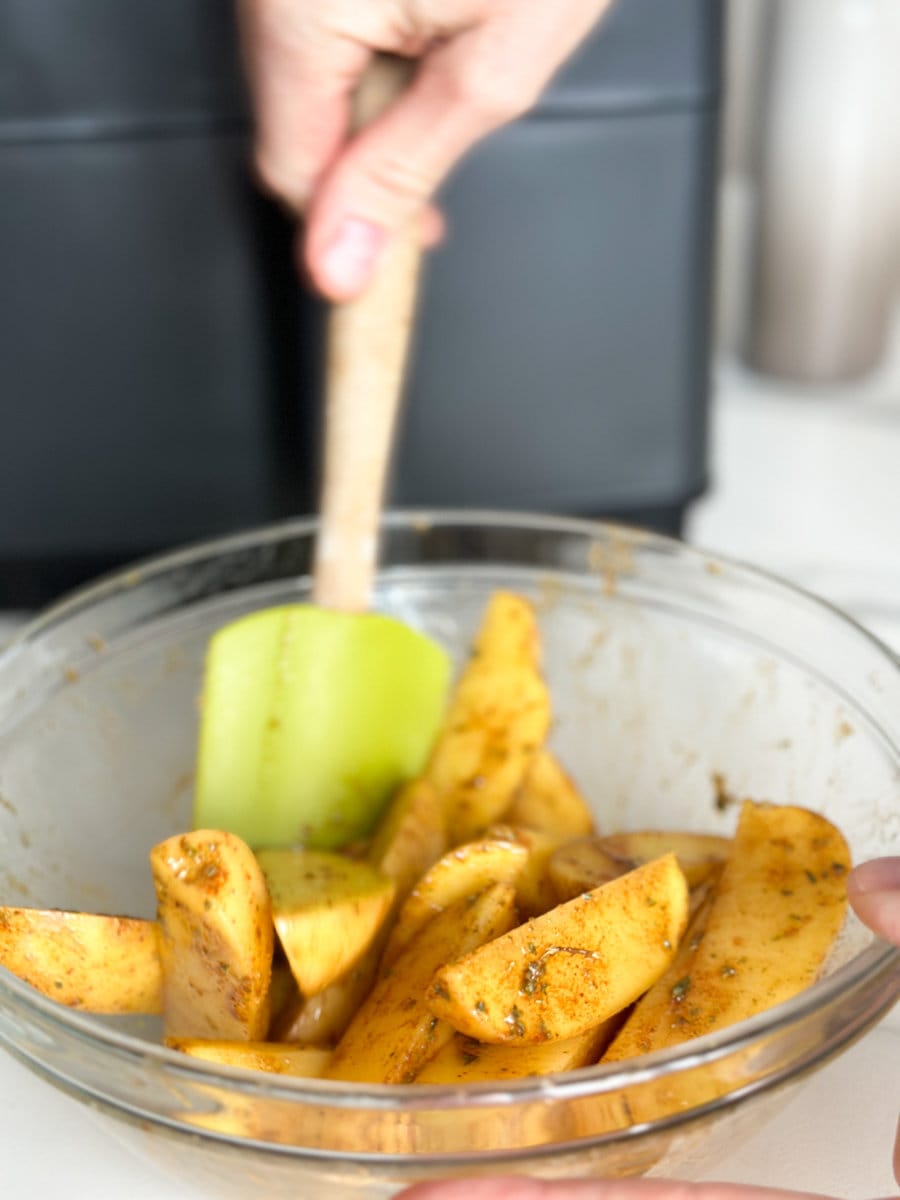 bol avec quartiers de pommes de terre et vinaigrette (main qui combine à la maryse) devant air fryer