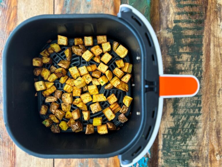 patates dejeuner dans le panier du air fryer sur une table de bois