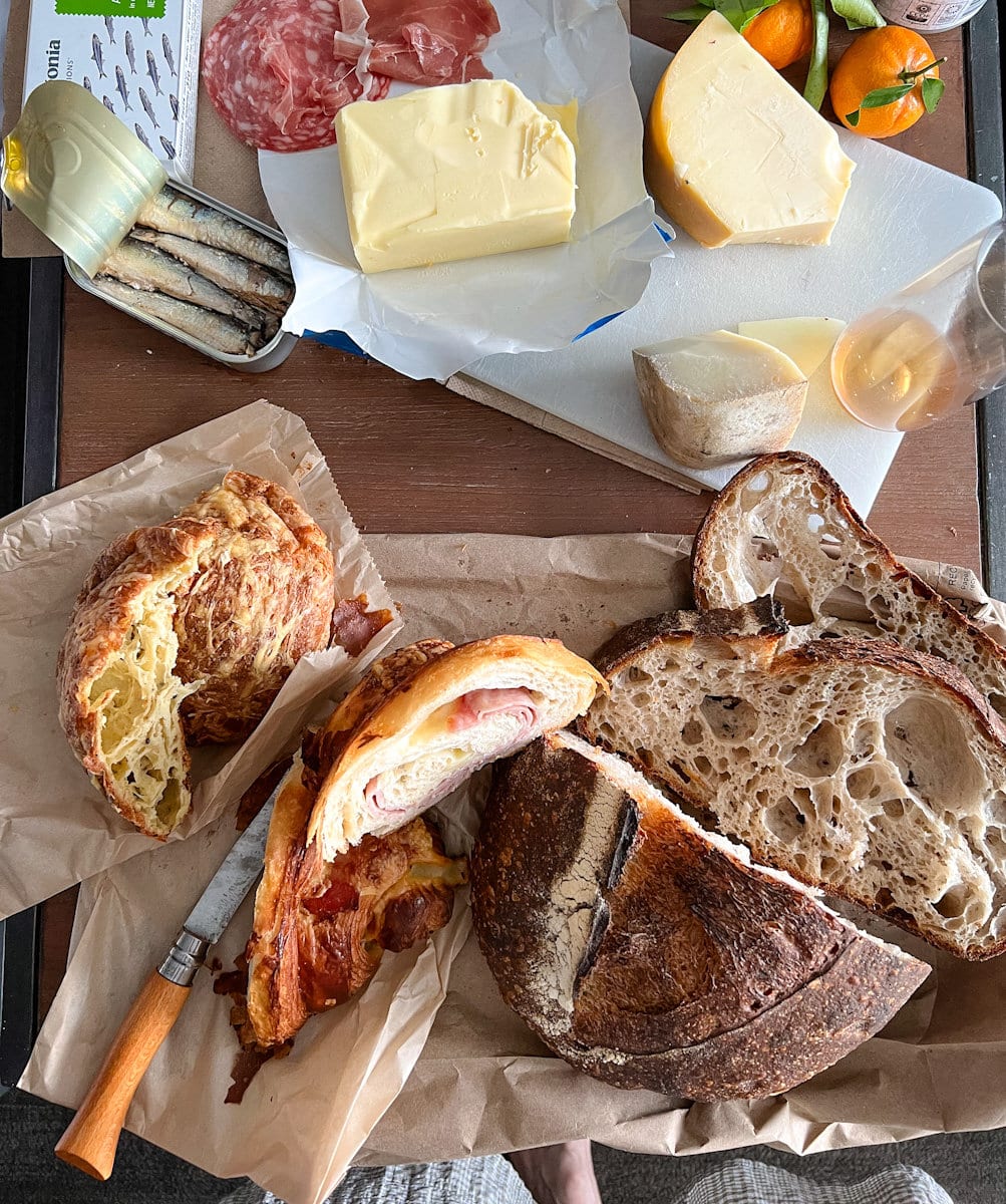 pain et viennoiseries achetés chez Tartine Bakery sur une planche à charcuterie