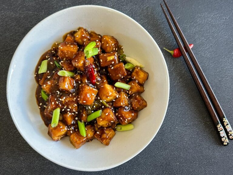 tofu Général Tao au air fryer, dans un bol blanc avec baguettes