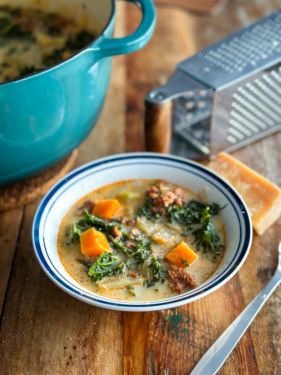 soupe toscane (zuppa toscane) dans un bol avec cocotte et râpe à fromage et parmesan 