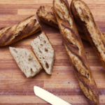 baguette maison sur la planche en bois coupée en deux
