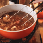 fondue chinoise dans un pot orange avec trois fourchettes
