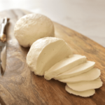 2 boules de mozzarella sur une planche une est tranchée