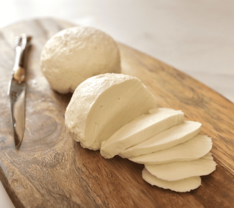 2 boules de mozzarella sur une planche une est tranchée