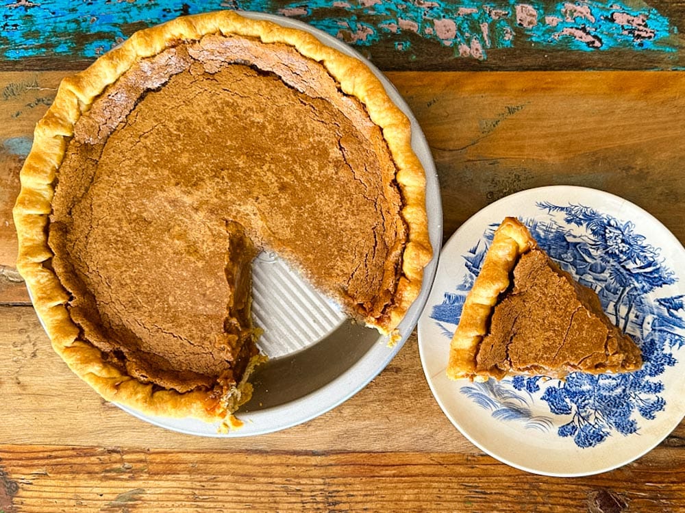 tarte au sucre avec pointe dans une assiette sur une table en bois