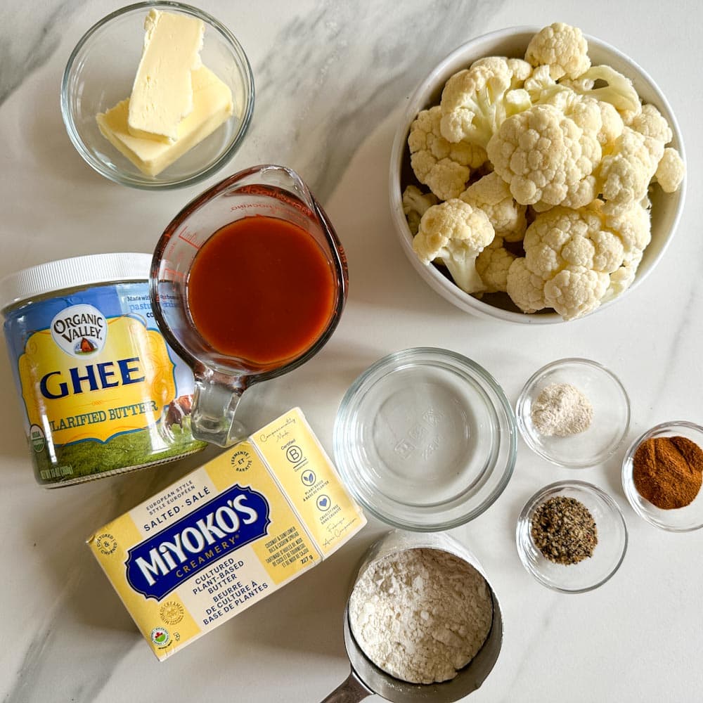 ingrédients pour croquettes chou fleur buffalo sur le comptoir: fleurons de chou fleur, sauce buffalo, beurre et substitut, farine, eau, épices
