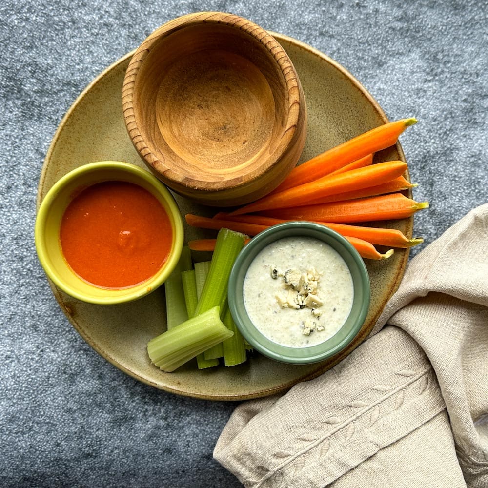 accompagnements à croquette buffalo: carottes, céleri, sauce au fromage bleu et sauce Buffalo dans une assiette avec linge de table 