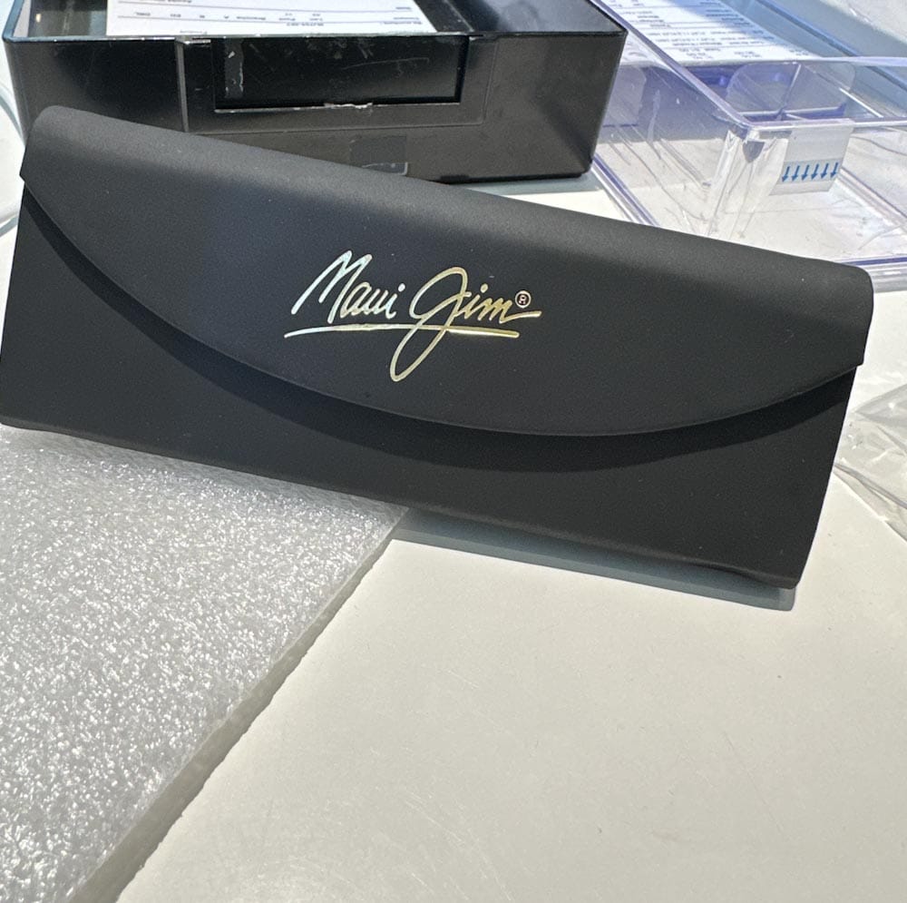 étui de lunettes fumées Maui Jim sur une table