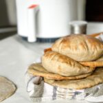 pains pita sur un linge devant un air fryer blanc