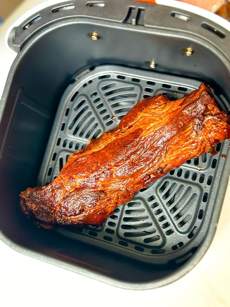 morceau d'épaule de porc marinade non encore cuite dans l'air fryer