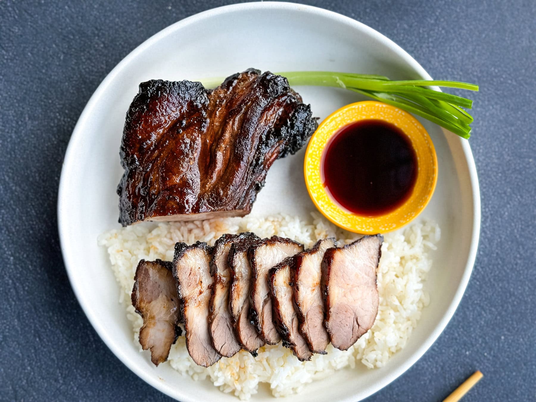 porc bbq char siu cuisson air fryer dans une assiette avec riz et oignon vert