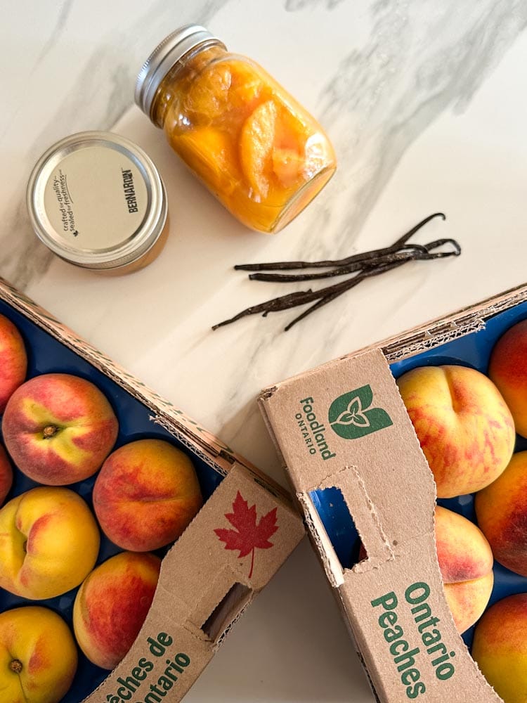 caisse de pêches de l'ontario, gousses de vanillle, un pot de conserve de pêches dans le sirop