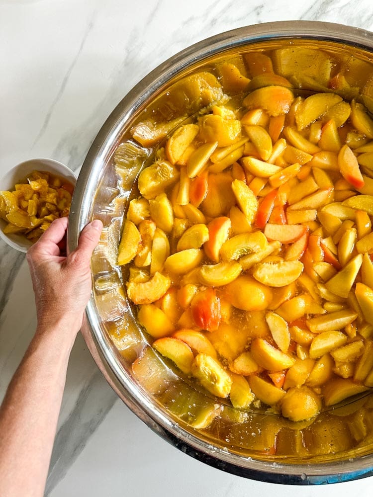 segment de pêches dans un cul-de-poule avec main qui tient