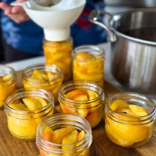 bocaux de conserve de pêches, verser sirop avec entonoir