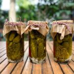 Cornichons marinés maison, 3 pots sur une table
