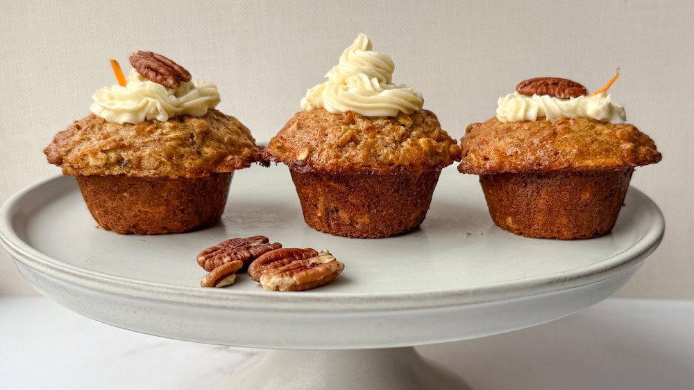 muffin aux carottes et à l'avoine avec glaçage au fromage à la crème et noix de pacane dans un plat de service