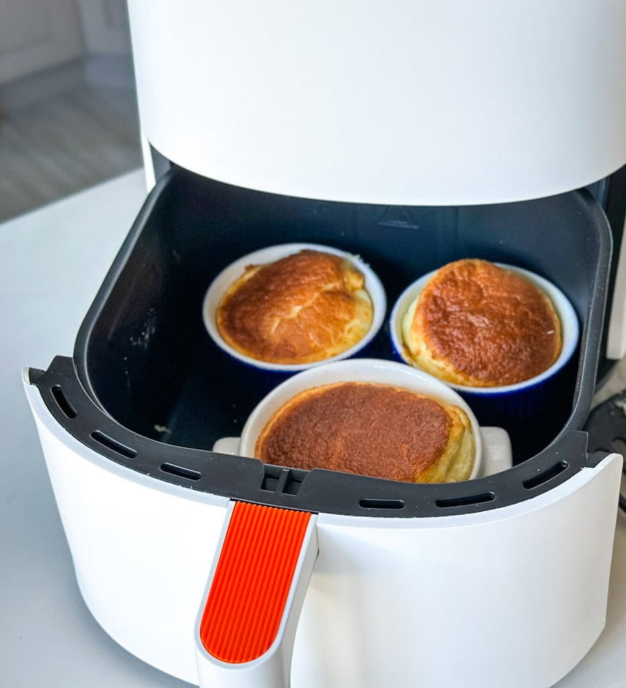 3 ramequins de soufflé au fromage dans le panier ouvert d'un air fryer blanc