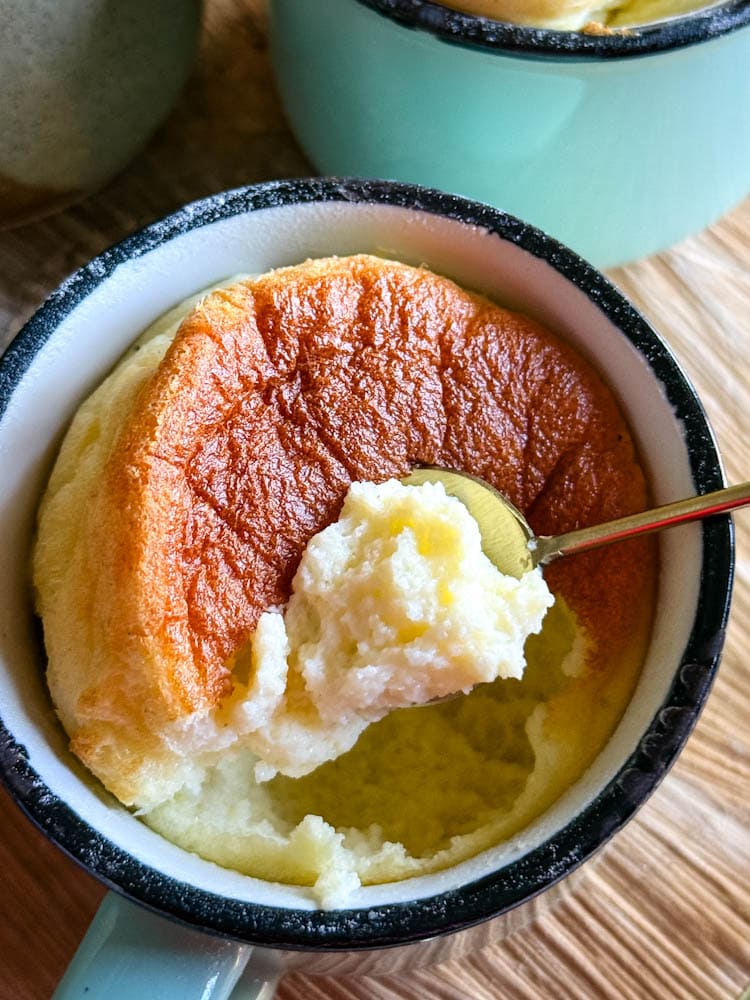 cuillère soulevant une bouchée de soufflé au fromage dans une tasse