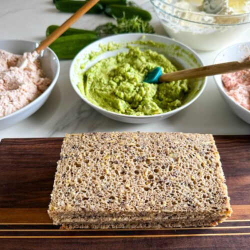 trois bols de garnitures à pain sandwich et tranches de pain en avant sur une planche