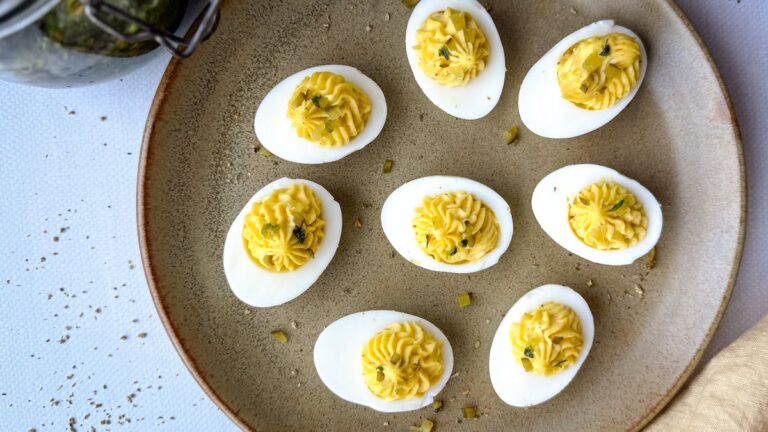 plusieurs oeufs mimosa aux herbes salées dans une assiette en grès brune