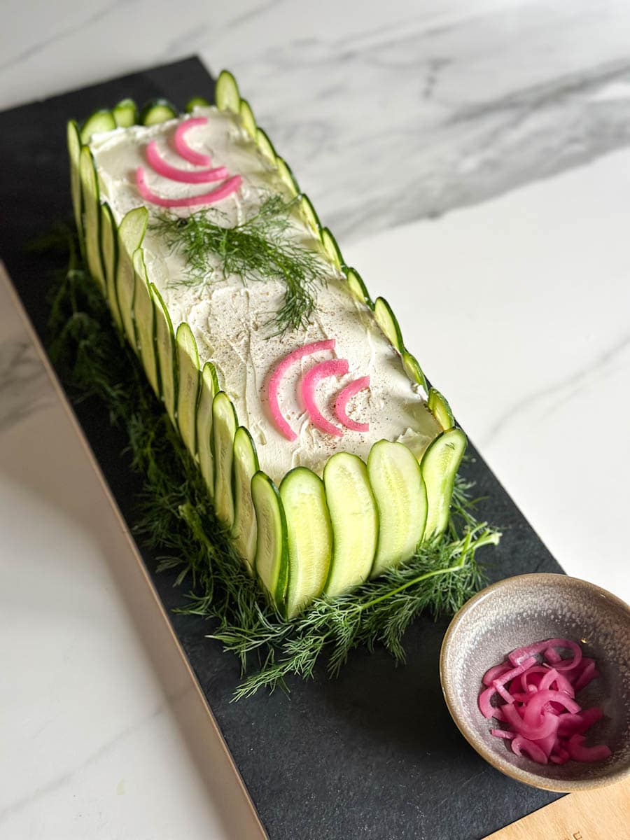 pain sandwich scandinave joliment décoré sur une planche en ardoise avec oignons rouge marinés