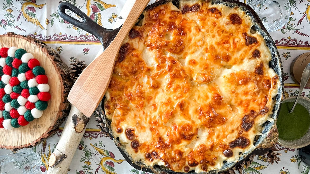gratin dauphinois gratiné dans une grande poêle en fonte sur une table festive