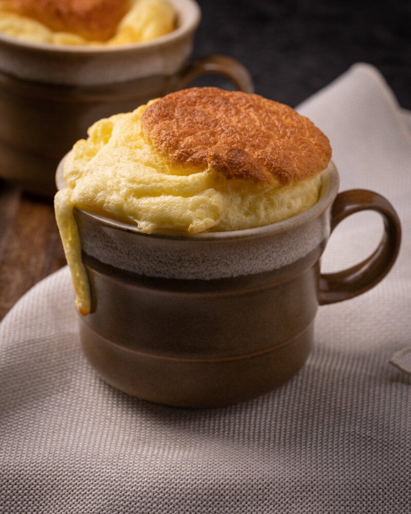 un soufflé au fromage individuel dans une tasse en poterie