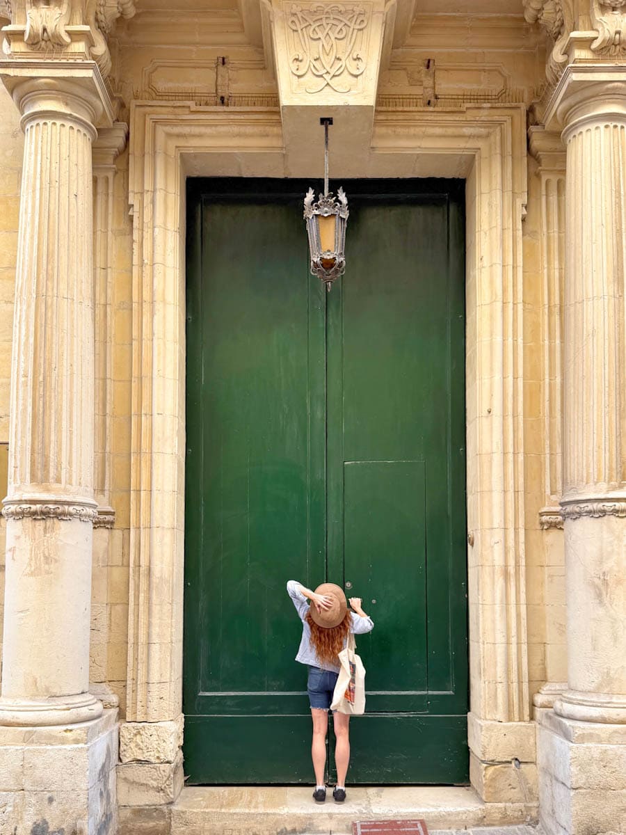Manon Lapierre devant une grande porte de Valette Malte