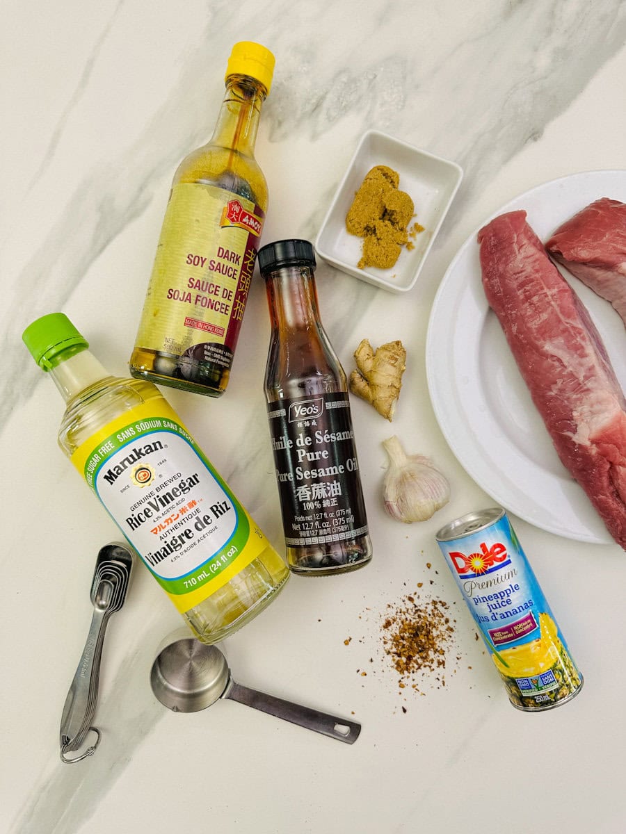 ingrédients sauce teriyaki sur comptoir: vinaigre de riz, sauce soja, huile de sésame et jus d'ananas en bouteille + épices, gingembre et ail