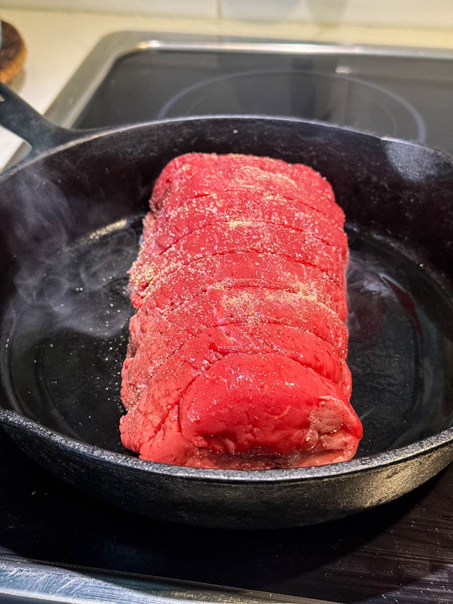 rôti français qui grille dans une poele en fonte