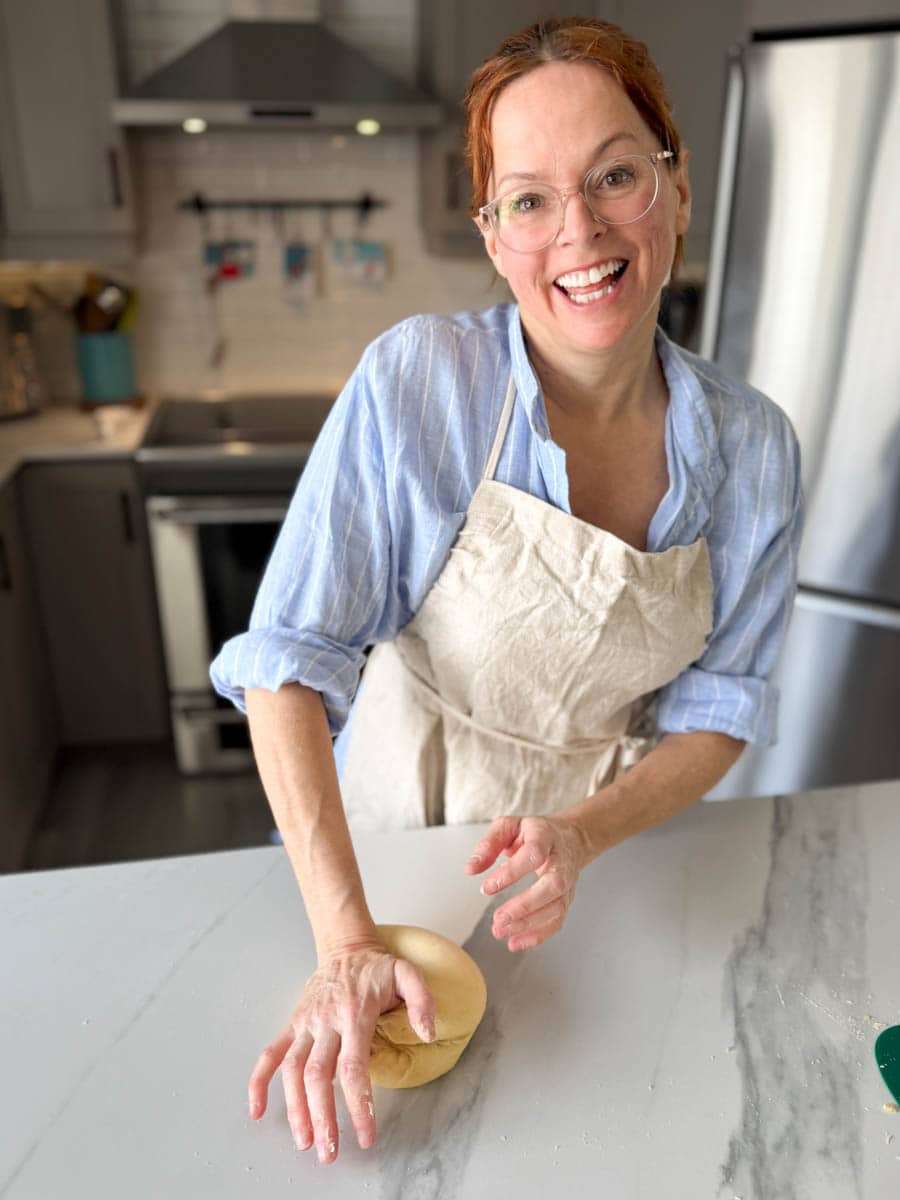 Manon Lapierre qui pétrit la pâte à pâtes maison au levain en souriant