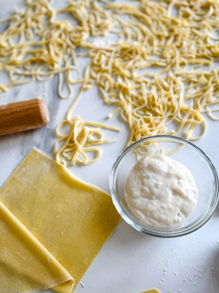 levain dans un bol avec spaghetti maison et pâte fraîche maison sur comptoir