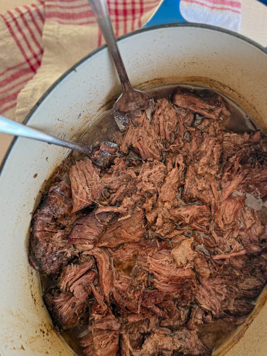 boeuf effiloche dans une cocotte avec deux fourchettes