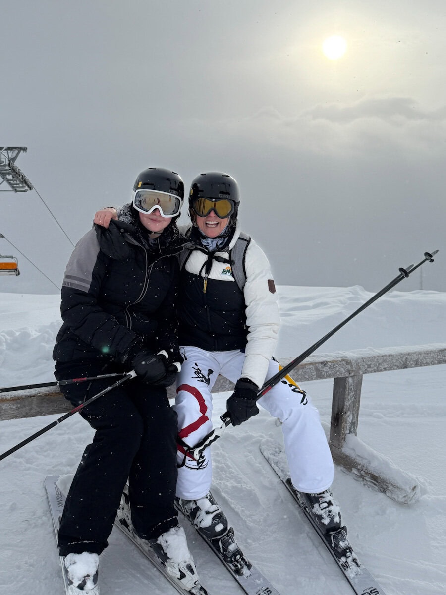 Manon Lapierre et fille en ski haut de piste, assises, dans la brume et la neige