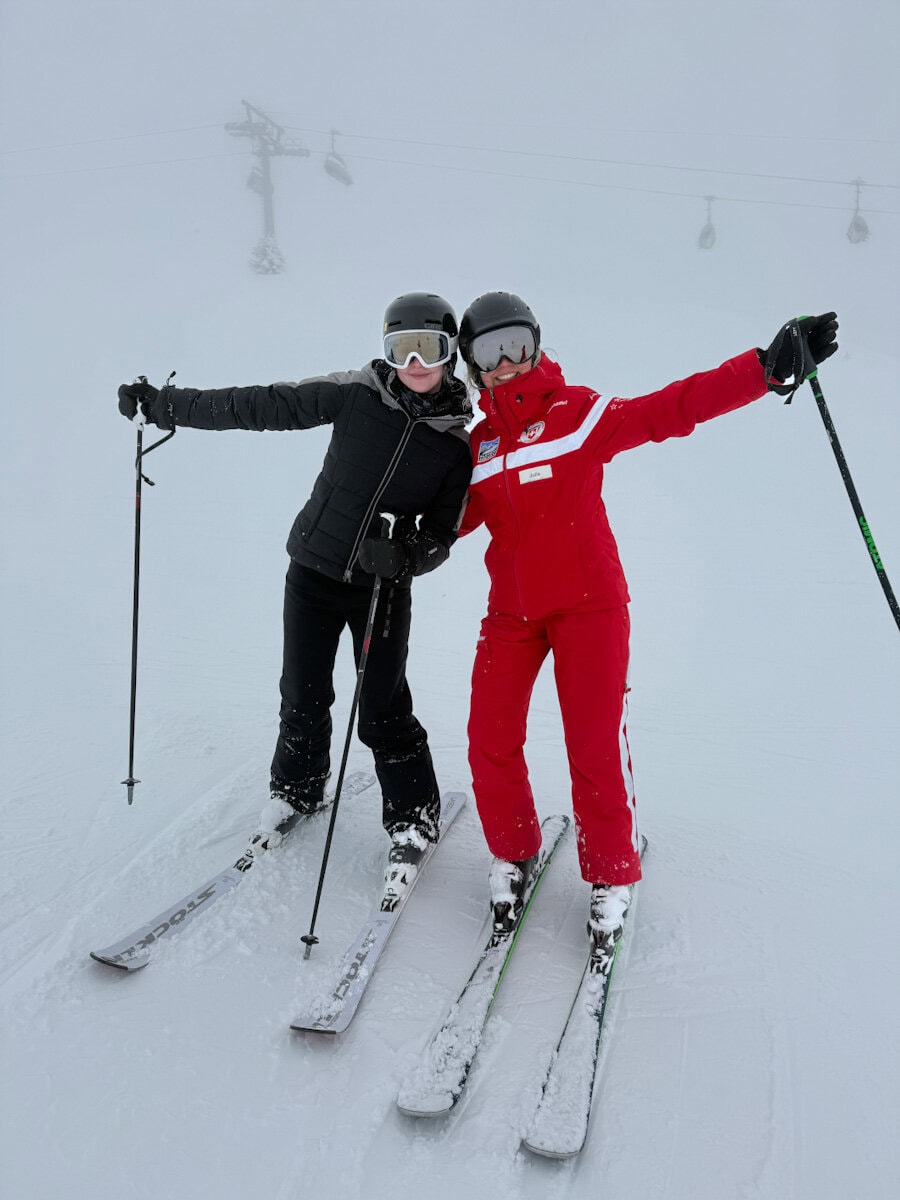 skieuse et monitrice de ski en Suisse sous paysage enneigé